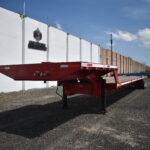 Cama baja de 53 pies operando en transporte de maquinaria pesada y carga sobredimensionada.